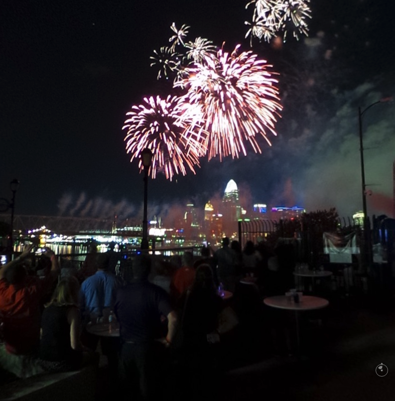 crowd with fireworks in background and Purple People Bridge silhouetted. Cincinnati in far distance