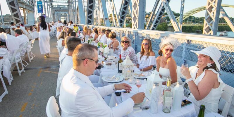 Dinner en Blanc on the Purple People Bridge with everyone wearing white and dining at long tables that span the bridge